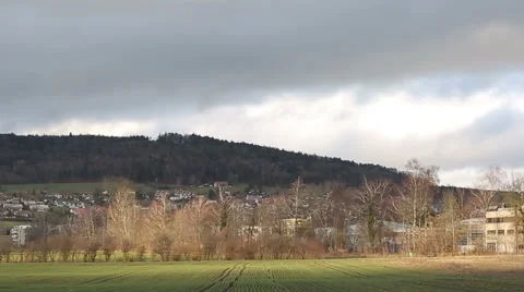 Clouds moving over a town with moments of sunshine. Time lapse Stock Footage 61205400