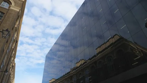 Clouds moving rapidly over a reflection of an old building on a glass building. Stock Footage 119668067