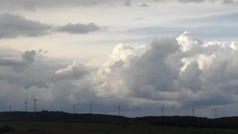 Clouds moving slowly, wind turbines with spinning rotor blades behind forest Stock Footage 80088173