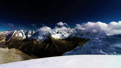 Clouds moving snow covered mountains Stock Footage 77444644