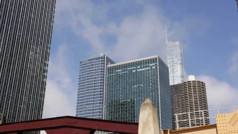 Clouds moving through skyscrapers as a train passes by in Chicago, Illinois Stock Footage 79700659