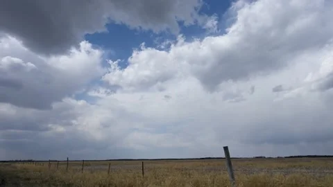 Clouds moving in time lapse above a dry farm field with fence in the foreground. Stock Footage 155113690