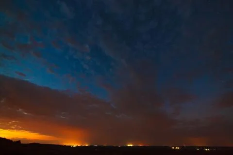 Clouds at night against the background of bright stars in the sky after sunse Stock Photos