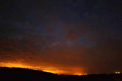 Clouds at night against the background of bright stars in the sky after sunse Stock Photos