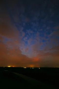 Clouds at night against the background of bright stars in the sky after sunse Stock Photos