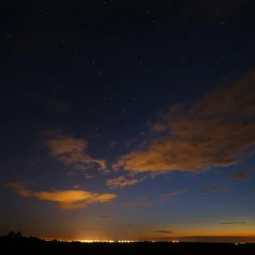 Clouds at night against the background of bright stars in the sky after sunse Stock Photos