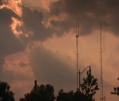 Clouds with orange sunlight over antenna towers Video stock 86695772