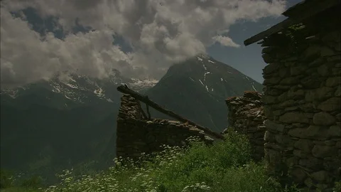 Clouds over the Alps with old stone building in the foreground Video stock 95600811