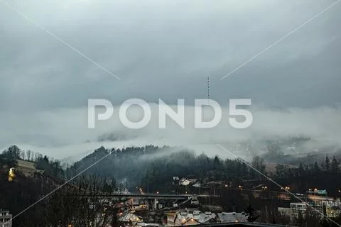 Clouds over broadcasting tower on the top of the hill. Foggy weather Stock Photos