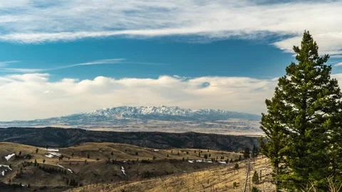 Clouds over Crazy Mountains in the distance Stock Footage 310567523