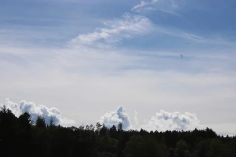 Clouds over a forest in the distance. Stock Photos