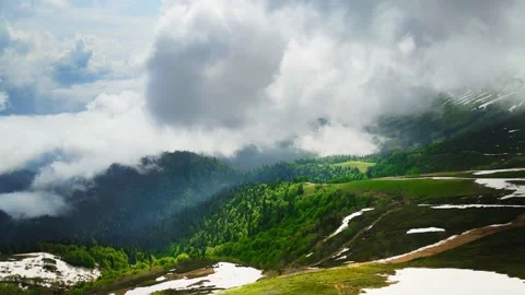 Clouds over the green mountains with snow in ski resort. Stock Footage 232199031