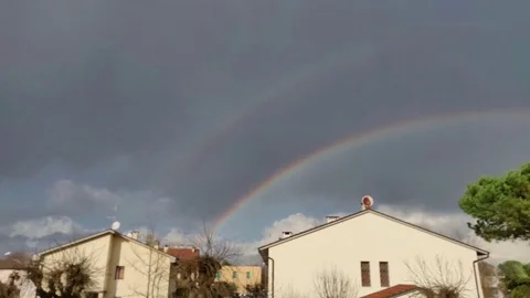 Clouds over the houses, with rainbow - Time lapse Stock Footage 121784182