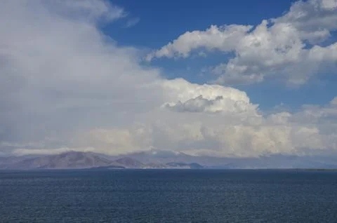 Clouds over lake Sevan and mountain range at background. Gegharkunik Province Stock Photos