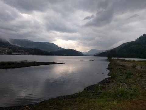 Clouds over the lake with view of small town Stock Photos