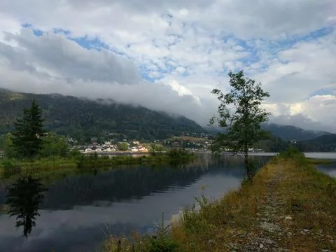 Clouds over the lake with view of small town Stock Photos