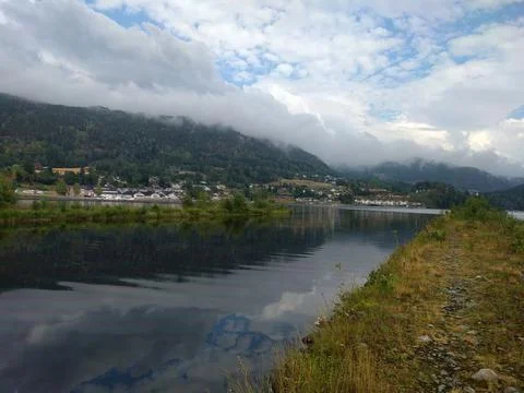 Clouds over the lake with view of small town Stock Photos
