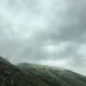 Clouds over a mountain Stock Photos