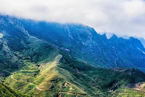 Clouds over mountain with serpantine road Stock Photos