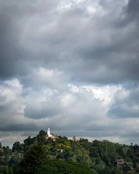 Clouds over the mountain. white buddha at the top of the mountain. Kandy, Sri Stock Photos