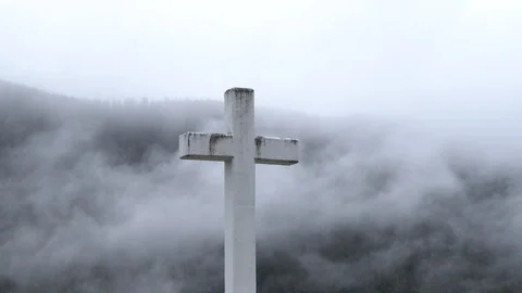 Clouds over the mountains behind a cross in Memorial Park in Sitka, Alaska Stock Footage 113254754