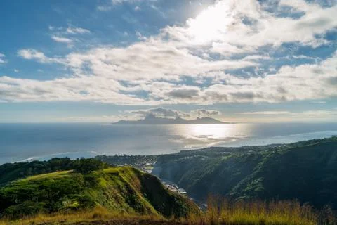 Clouds over the ocean in front of an island Stock Photos