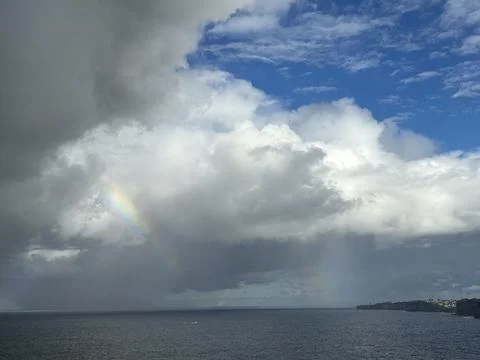 Clouds over ocean with a rainbow Stock Photos