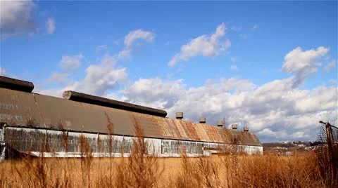 Clouds Over a Remote, Rundown Storage Building in a Field of Tall Grass Video stock 22243443