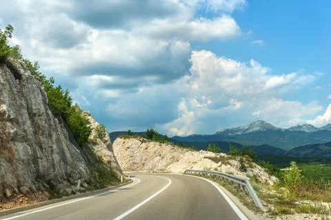 Clouds over road in mountains Stock Photos
