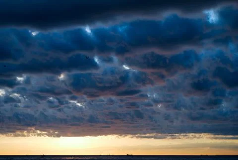 Clouds over the sea at dusk Stock Photos