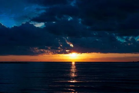 Clouds over the sea at sunset Stock Photos