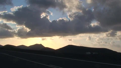 Clouds over silhoute volcanic landscape, in front of road Stock Footage 51843097