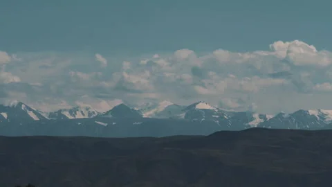Clouds over snow-capped mountain peaks Видео 245290022
