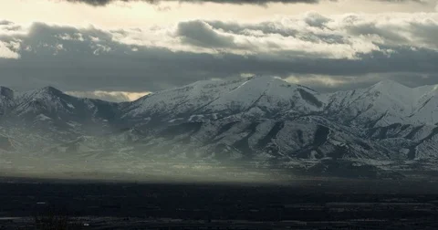 Clouds over the snow covered mountains at sunset Stock Footage 77768643