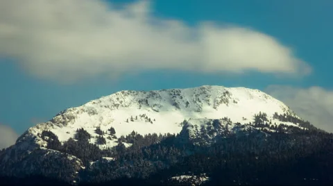 Clouds over snowy mountain peak extreme telephoto timelapse Stock Footage 49976097