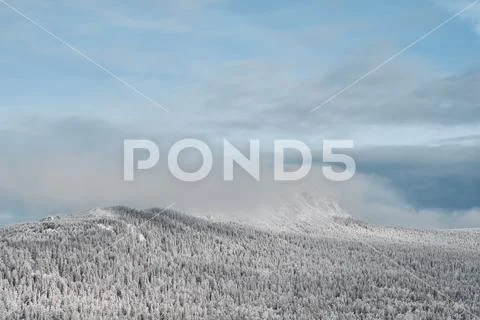 Clouds over snowy winter forest and mountains Stock Photos