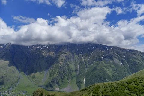 Clouds over steep green slopes in Georgian mountain valley Stock Photos