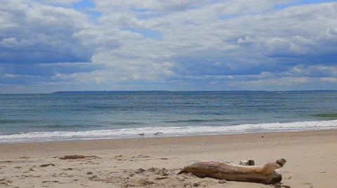 Clouds over waves touching sandy beach Stock Footage 63475381