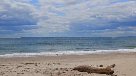 Clouds over waves touching sandy beach Stock Footage 69172888