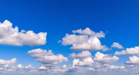 Clouds in panoramic sky. Clouds against blue background. Cumulus clouds across Stock Photos
