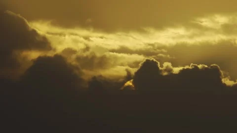 Clouds part to reveal sun, casting golden rays through storm 스톡 동영상 337799593