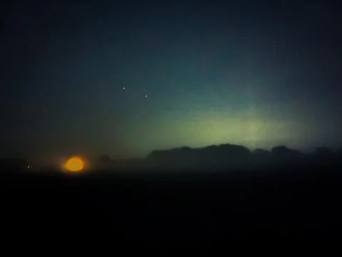 Clouds part as the sun shines through the night sky Foto stock