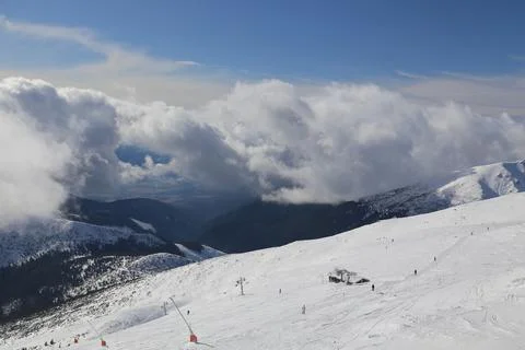 Clouds parting over a ski slope and forested valley Fotos Stock
