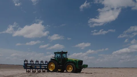 Clouds pass behind a parked tractor in Texas, 4K. Stock Footage 93533838