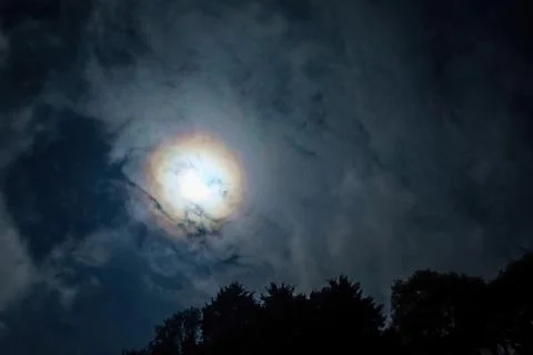 Clouds pass in front of the moon in a night sky. Stock Photos