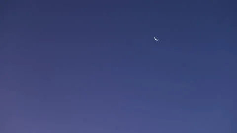 Clouds pass in front of the waning crescent moon as it moves slowly across the Stock Footage 94313688