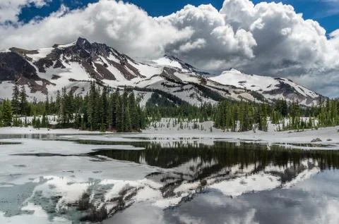 Clouds pass over Mt Jefferson as Scout Lake thaws in the spring. Stock Photos