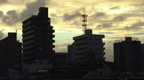 Clouds Pass Over Silhouetted Apartment Building In Tokyo At Sunset Video stock 50722433