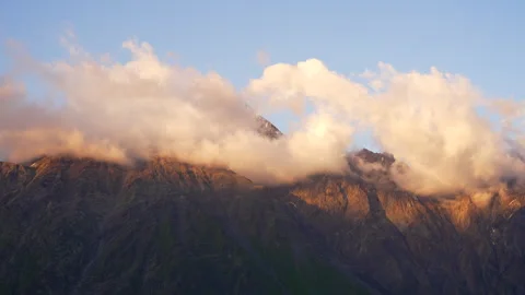Clouds passing above Kazbegi mountains during sunset Stock Footage 250601431