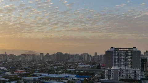 Clouds passing by and city getting darker as night approaches Stock Footage 98116544